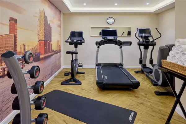 Fitness-Bereich des Louis C. Jacob in einem Raum mit einer großen Fototapete.