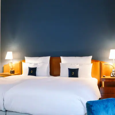 Ein Bett vor einer blauen Wand im Hotel Louis C. Jacob.