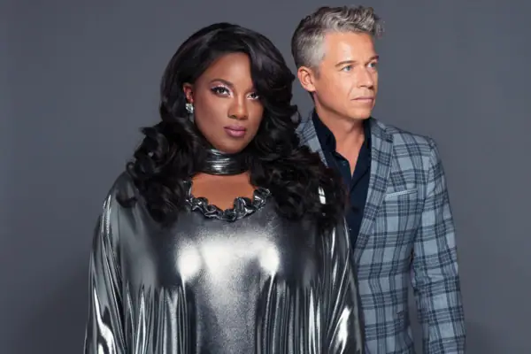 The Terri Green Project Ein Mann und eine Frau posieren für ein Foto vor einer grauen Wand.