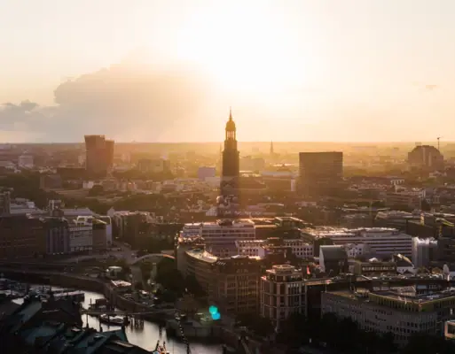 Stadtansicht mit hohem Turm bei Sonnenuntergang