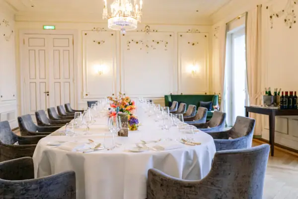 Festlich gedeckte Tafel mit blauen Sesseln in einem Veranstaltungsraum im Hotel Louis C. Jacob.