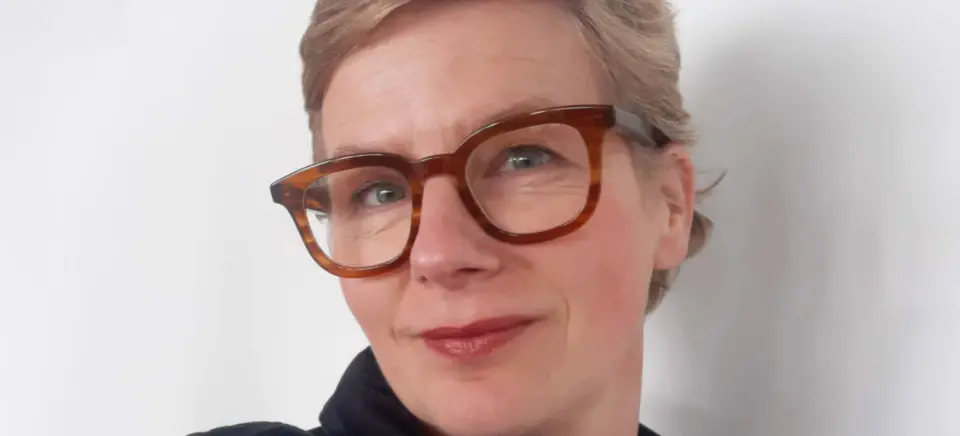 Eine lächelnde Frau mit Brille.