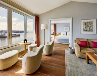 Zimmer & Suiten Zimmer mit Blick auf das Wasser und ein Bett im Vordergrund.