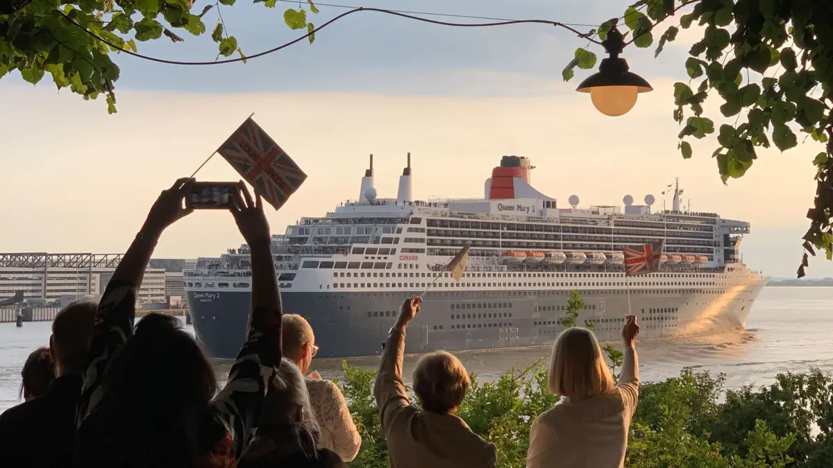 Eine Gruppe von Menschen steht vor einem großen Schiff.