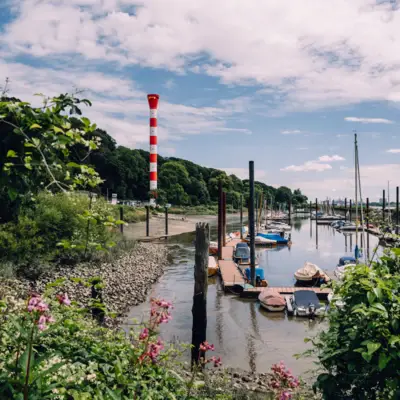 Strandweg in Blankenese mit Leuchtturm und Yachthafen.