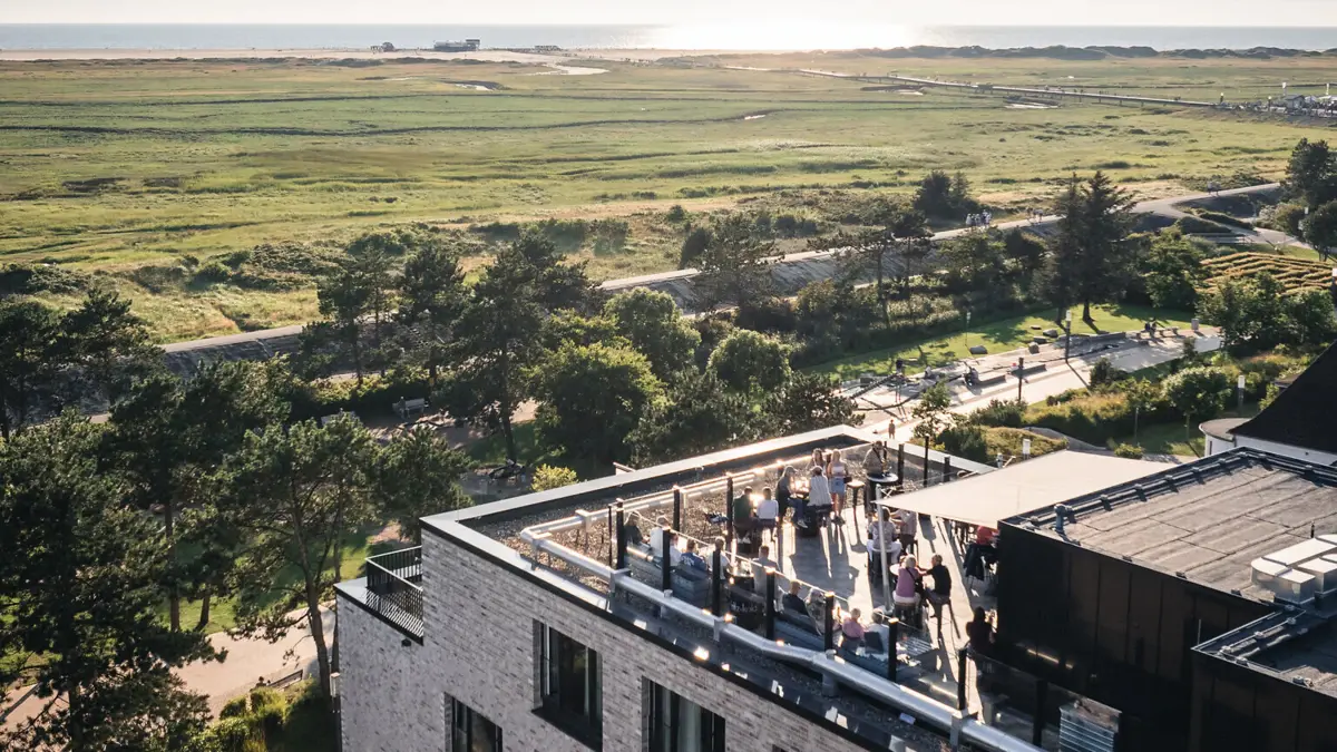 Rooftop Bar St. Peter-Ording Die Rooftop Bar Scraper's Club im Urban Nature Hotel St. Peter-Ording von oben fotografiert, im Hintergrund ist das Meer zu sehen.