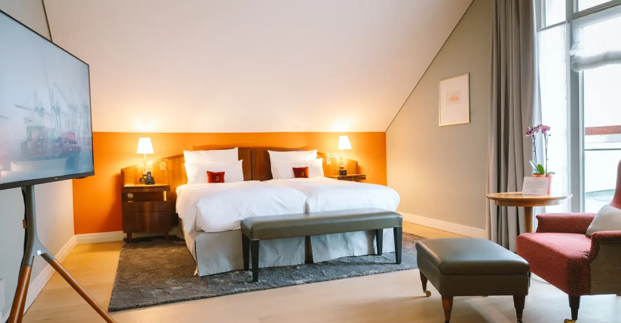 Ein Schlafzimmer mit einem Bett und einem Hocker.