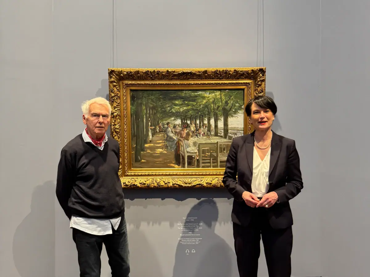 Ein Mann und eine Frau stehen neben einem Gemälde.