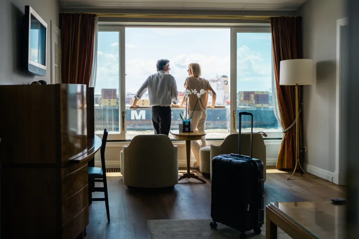 Ein Mann und eine Frau stehen in einem Raum mit einem Fenster.