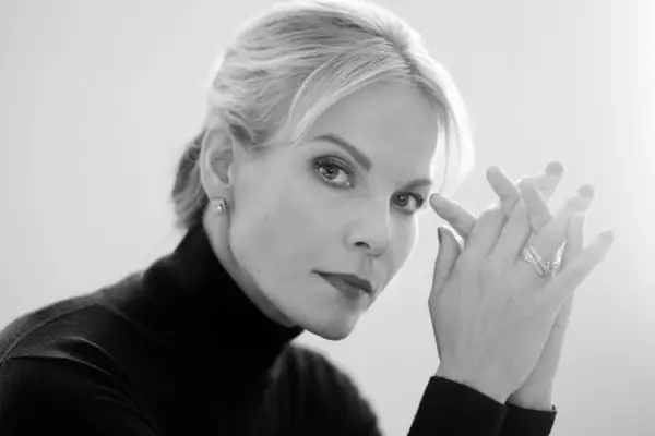 Eine Frau berührt ihr Auge in einem Schwarz-Weiß-Porträt.