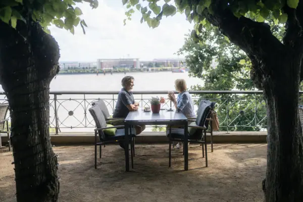 Paar auf der Lindenterrasse Ein Mann und eine Frau sitzen an einem Tisch im Freien.