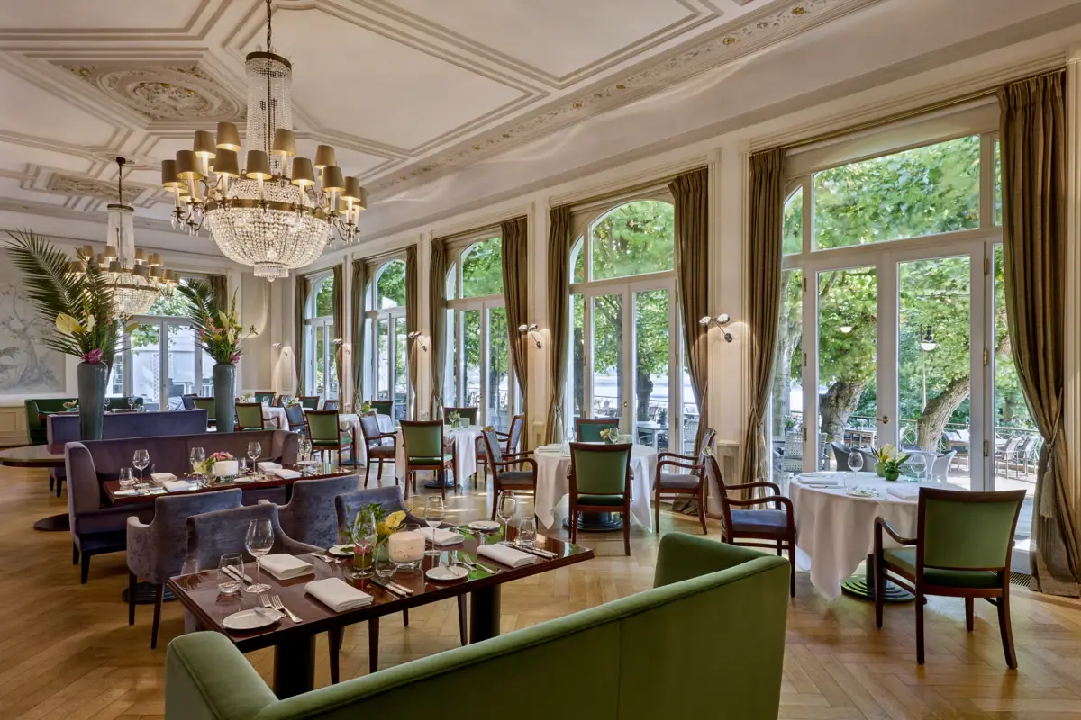 Restaurant mit gedeckten Tischen und Kronleuchtern.