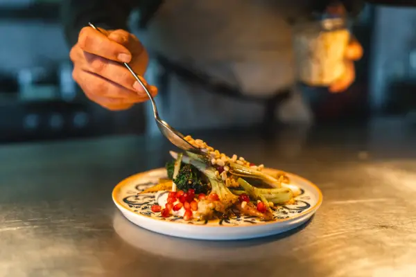 Gericht Auntie Clara Restaurant St. Peter-Ording Ein Teller wird von einem Koch im Auntie Clara Restaurant St. Peter-Ording angerichtet.