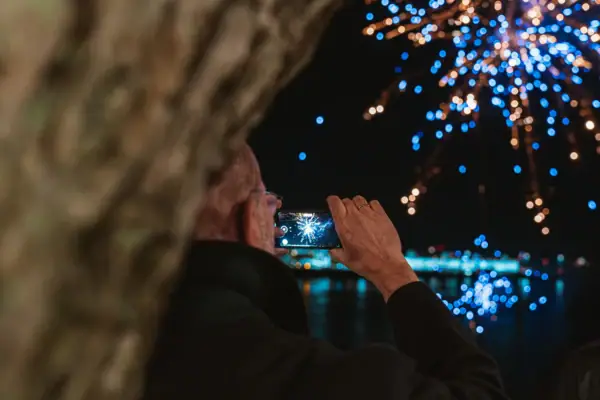 Ein Mann fotografiert ein Feuerwerk.