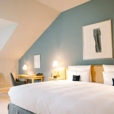 Ein Hotelzimmer mit einem Bett und Schreibtisch mit einem Stuhl davor.