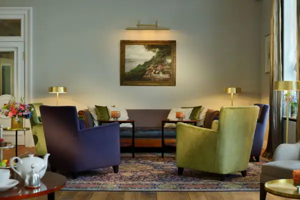 Die Wohnhalle des Hotels Louis C. Jacob mit Sesseln und einem Couchtisch. An der Wand hängt ein Gemälde.