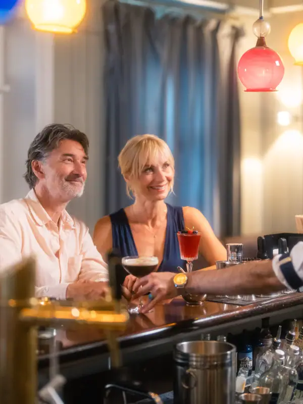 Ein Paar sitzt am Tresen der Jacobs Bar und spricht mit dem Barkeeper