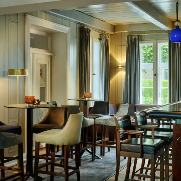 Jacobs Bar mkit hohen Tischen und Hockern, sowie einem hölzernen Tresen im Hotel Louis C. Jacob.