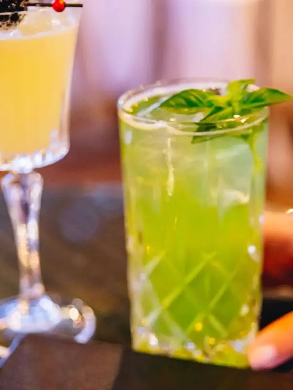Cocktailgläser mit gelben und grünen Flüssigkeiten.