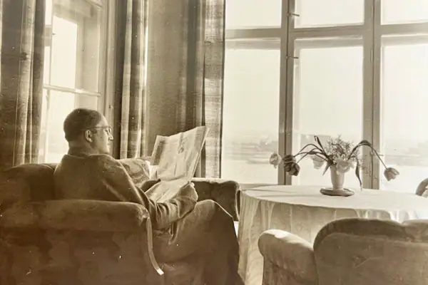 Wiedereröffnung Ein Mann sitzt in einem Stuhl und liest eine Zeitung.