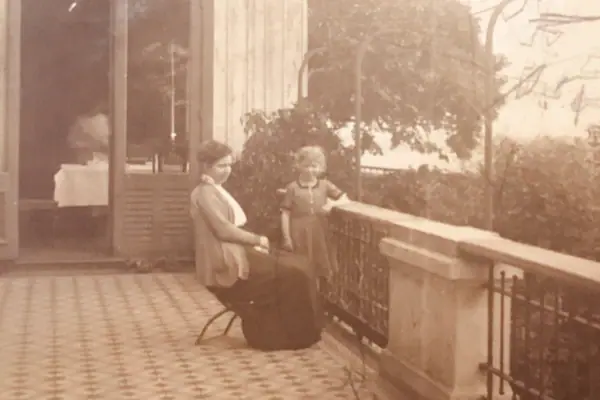 Eine Frau und ein Kind sitzen auf einer Veranda.