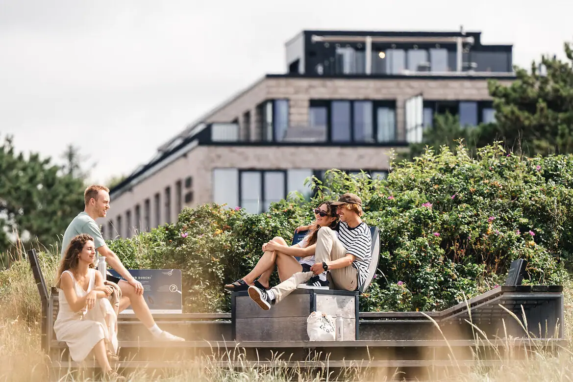 Urban Nature Hotels Eine Gruppe von Menschen sitzt auf einer Bank im Freien.