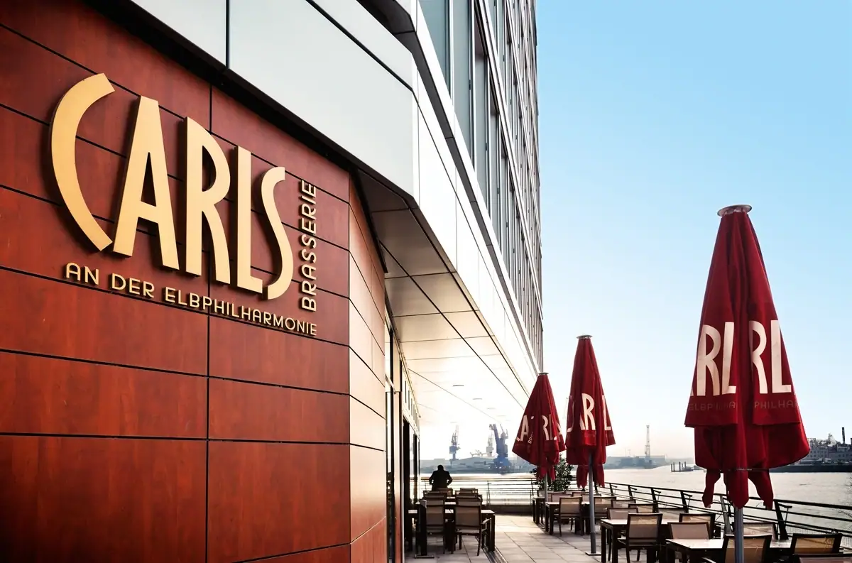 CARLS Restaurant mit Tischen und Stühlen im Freien.