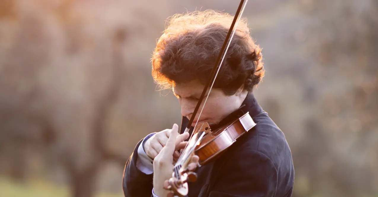 Augustin Hadelich spielt seine Violine in der Natur. 