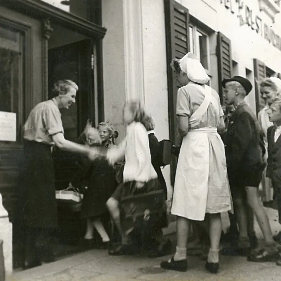 Eine Gruppe von Menschen steht vor einem Gebäude.