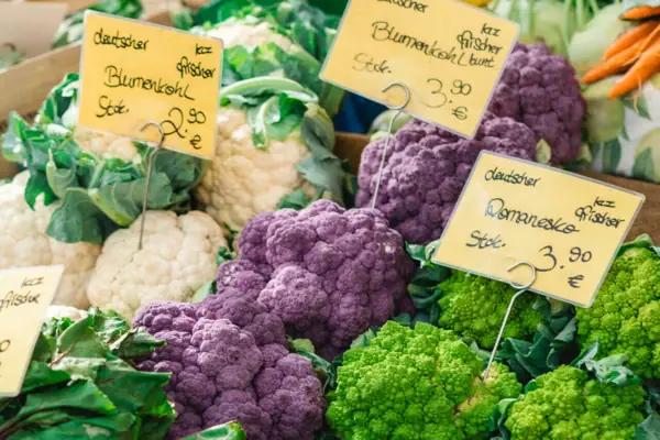 Stand Isemarkt Eine Gruppe von Gemüse mit Preisschildern.