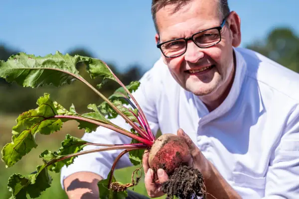 Ein Mann hält eine Rübe.