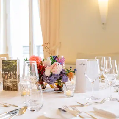 Ein Tisch mit Blumenarrangement und Gläsern.