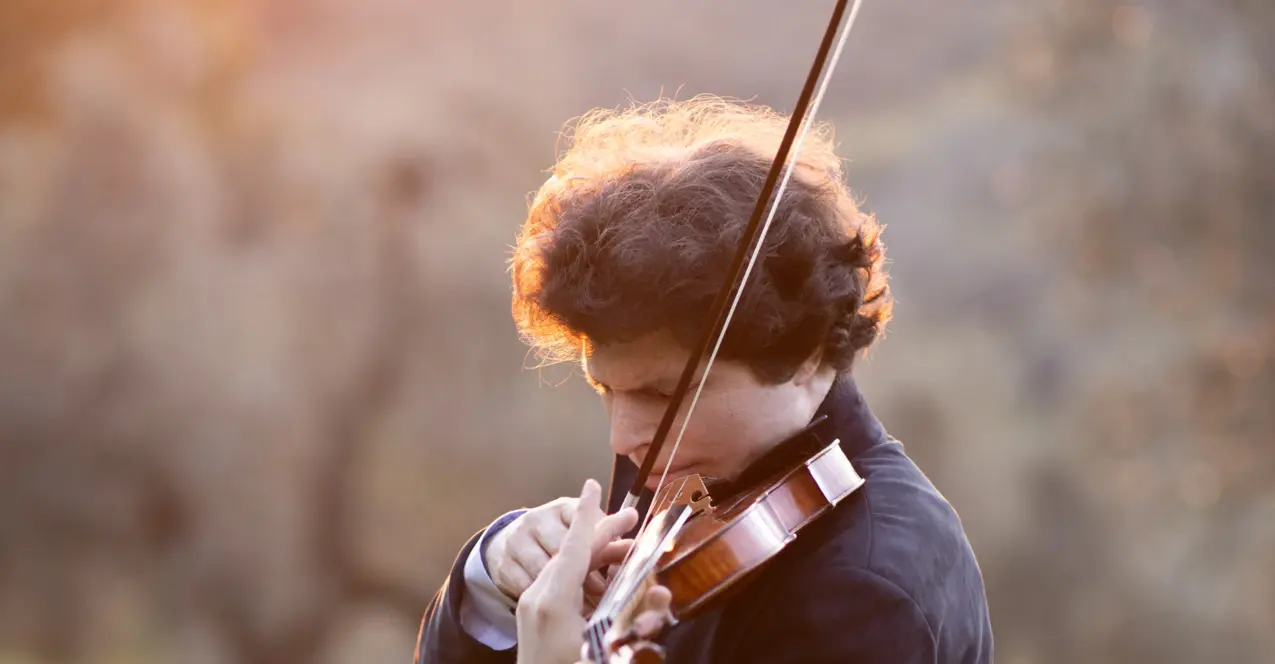 Augustin Hadelich spielt seine Violine in der Natur. 