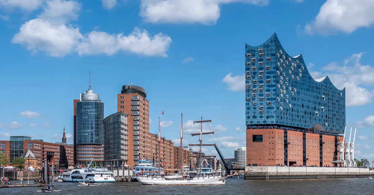 Blick auf die Elbphilharmonie und den umliegenden Hafen bei Sonnenschein.