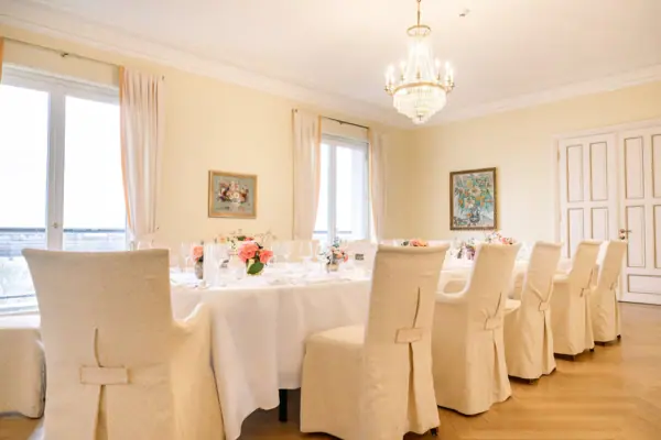 Ein festlich gedeckter Tisch mit Tischdecke und Vase als Mittelpunkt.