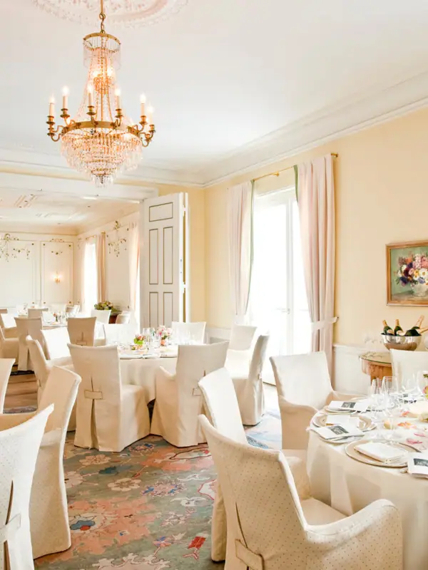 Veranstaltungssaal im Hotel Louis C. Jacob mit runden, gedeckten Tischen und Kronleuchtern.