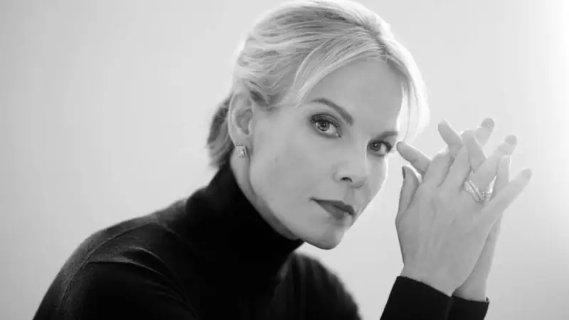 Eine Frau berührt ihr Auge in einem Schwarz-Weiß-Porträt.