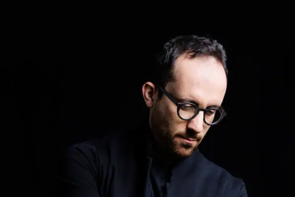 Igor Levit Ein Mann mit schwarzem Hemd und Brille.