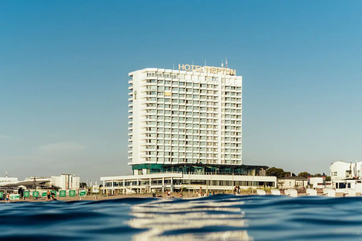 Hotel Neptun Gebäude im Hintergrund eines Gewässers mit klarem Himmel.