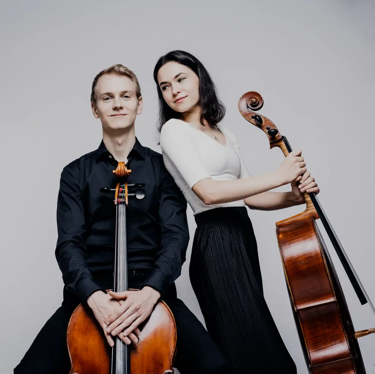 Cello-Duo Anna Olivia Amaya Farias und Fabian Sturm Ein Mann und eine Frau posieren mit zwei Cellos.