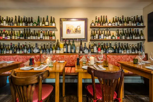 Ein Tisch mit Weinflaschen an der Wand.