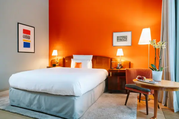 Ein Bett in einem Hotelzimmer mit orangefarbenen Wänden.