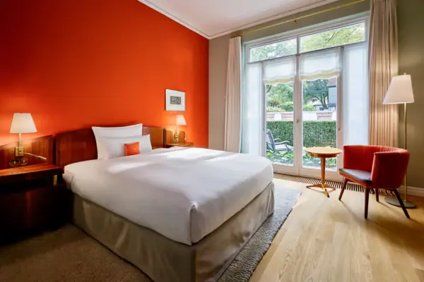 Ein Bett in einem Hotelzimmer mit orangefarbenen Wänden.