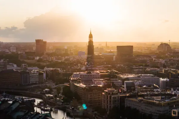 Eine Stadt mit einem hohen Turm bei Sonnenuntergang.