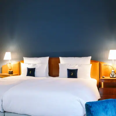 Ein Bett vor einer blauen Wand im Hotel Louis C. Jacob.