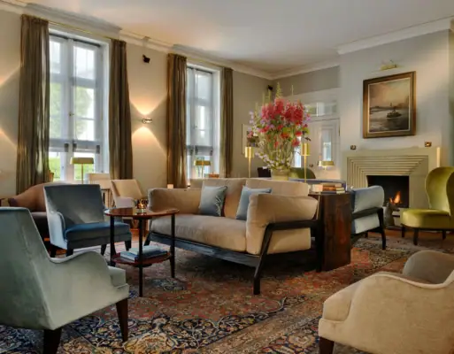 Die gemütliche Wohnhalle im Hotel Louis C. Jacob mit Kamin, einigen Sesseln und Sofas.