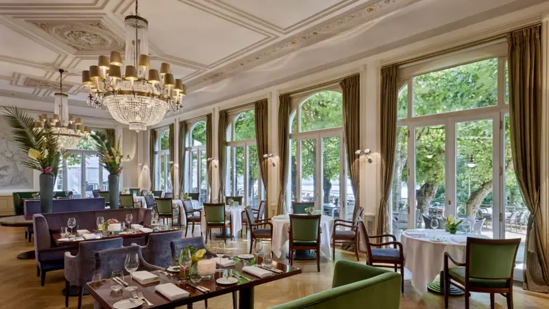 Das Jacobs Restaurant mit Tischen und Stühlen, dekoriert mit Kronleuchtern.