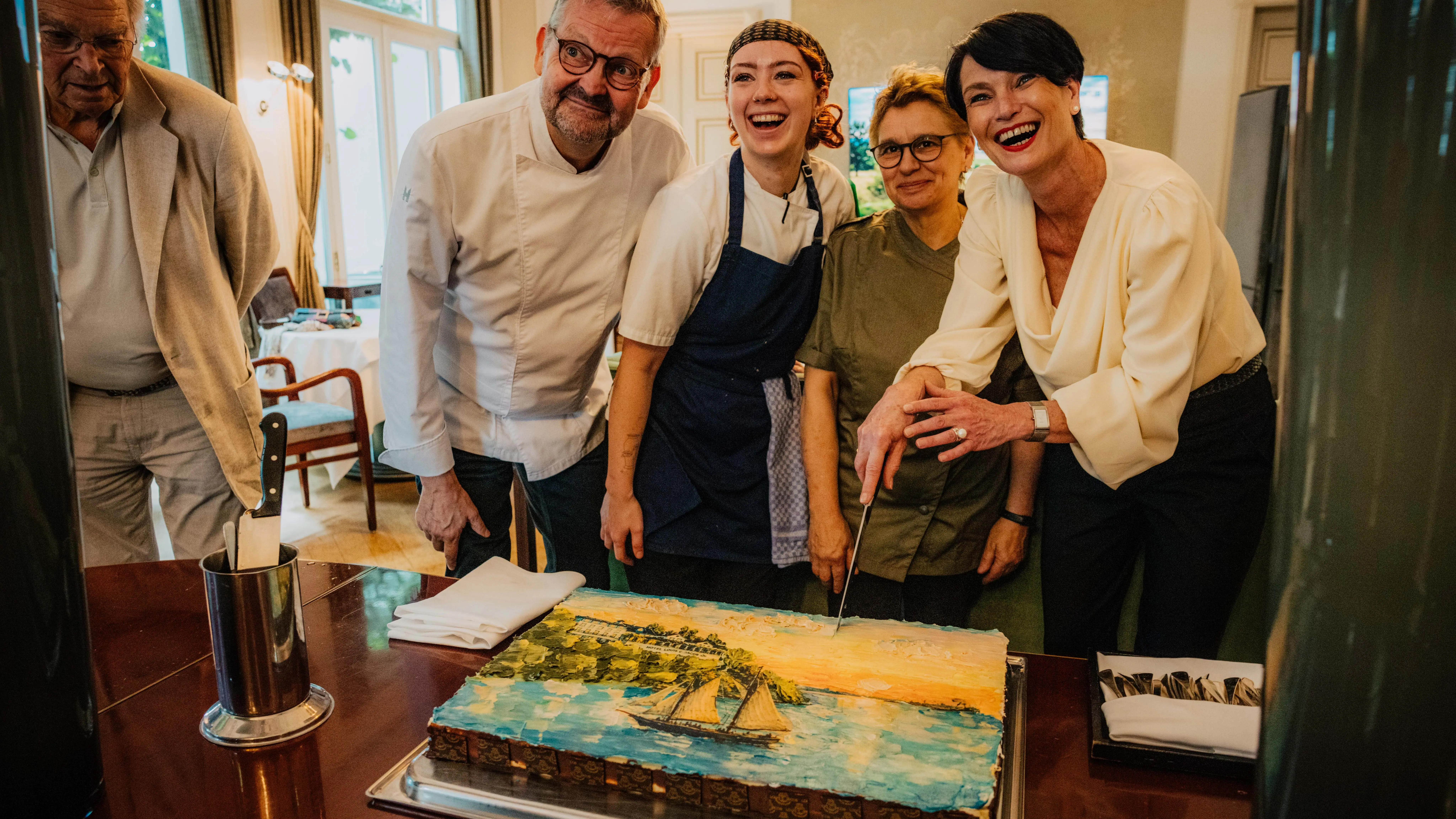 Eine Gruppe von Menschen steht um einen Kuchen.