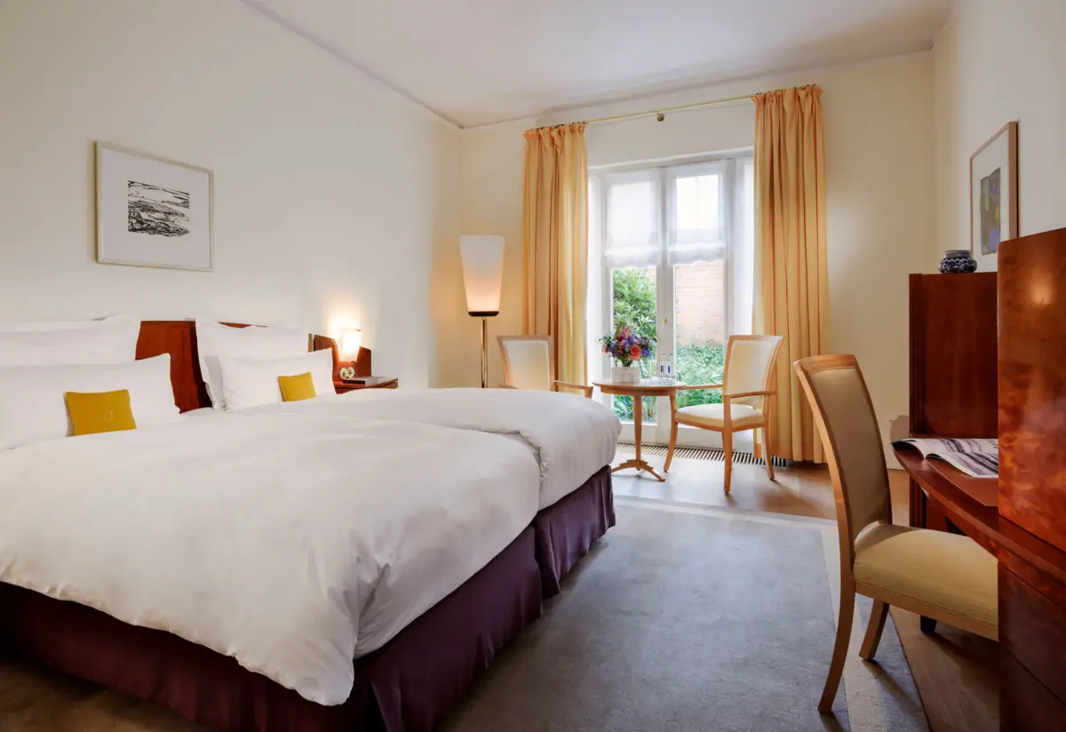Ein Zimmer mit einem Bett und Stühlen.