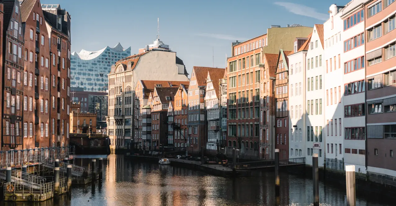 Die Hamburger Speicherstatt durch die ein Kanal verläuft und die Elbphilharmonie im Hintergrund. 